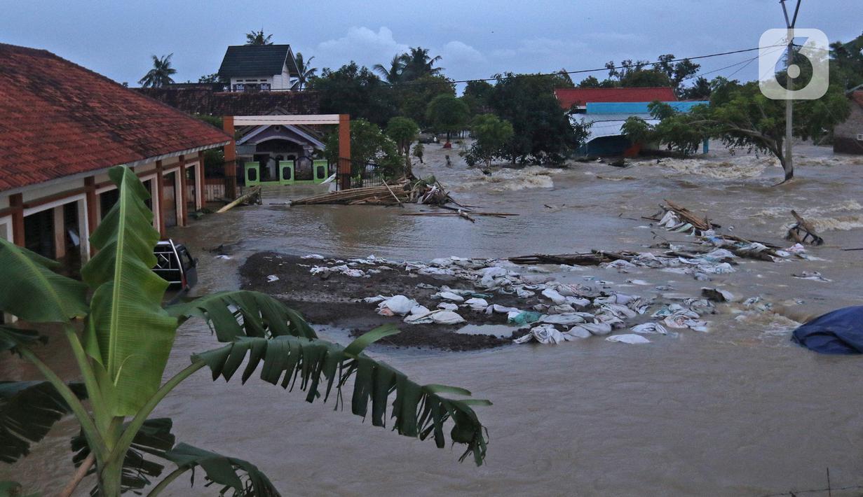 Suasana banjir akibat tanggul jebol di Desa Sumberurip Pebayuran, Kabupaten Bekasi, Jawa Barat, Senin (22/2/2021). Banjir akibat luapan sungai Citarum mengakibatkan 5 Desa terisolir selama tiga hari akibat tanggul sungai Citarum jebol. (Liputan6.com/Herman Zakharia)
