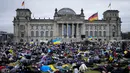 Orang-orang berbaring di tanah melambangkan mereka yang tewas dalam perang di Ukraina selama demonstrasi menentang invasi Rusia, di depan gedung Reichstag di Berlin, Jerman, 6 April 2022. Pengunjuk rasa menuntut Berlin berhenti membeli minyak dan gas Rusia. (AP Photo/Markus Schreiber)