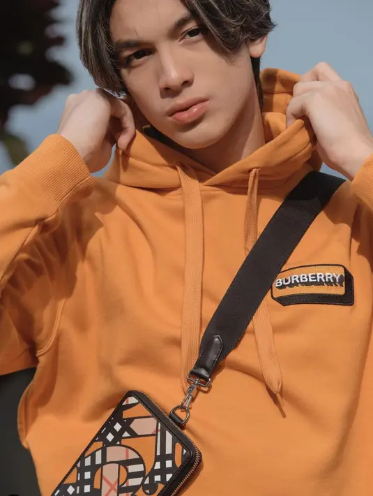Kali ini ia juga terlihat begitu memukau dengan hoodie Burberry bernuansa oranye. Pose yang begitu effortless hadirkan pesona yang sempurna.  [Foto: Instagram/ Eddy Meijer]