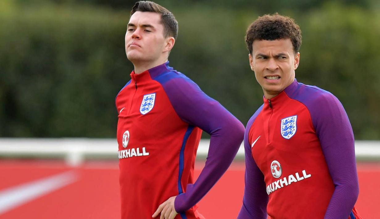 Pemain Inggris, Michael Keane (kiri) dan Dele Ali saat mengikuti sesi latihan di Tottenham Hotspur Training Ground, Enfield, (4/10/2017). Jika menang atas Slovenia, Inggris dipastikan lolos ke putaran final Piala Dunia 2018.  (AFP/Olly Greenwood)