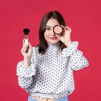 Wanita memegang brush di tangan kiri dan blush di depan matanya (Foto: Freepik/KamranAydinov).