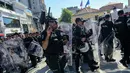 Petugas polisi anti huru hara lengkap menggunakan tameng menutup jalan di Istiklal Street Turki, pusat kota Istanbul, Minggu (25/6). Pihak berwenang menggagalkan parade Gay Pride setelah dilarang oleh gubernur setempat. (YASIN AKGUL/AFP)