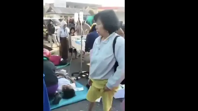 Seorang pasien terbaring di atas alas yang diletakkan di jalan, sementara petugas medis bergerak cepat melakukan pemeriksaan usai Gempa NTT (Istimewa)