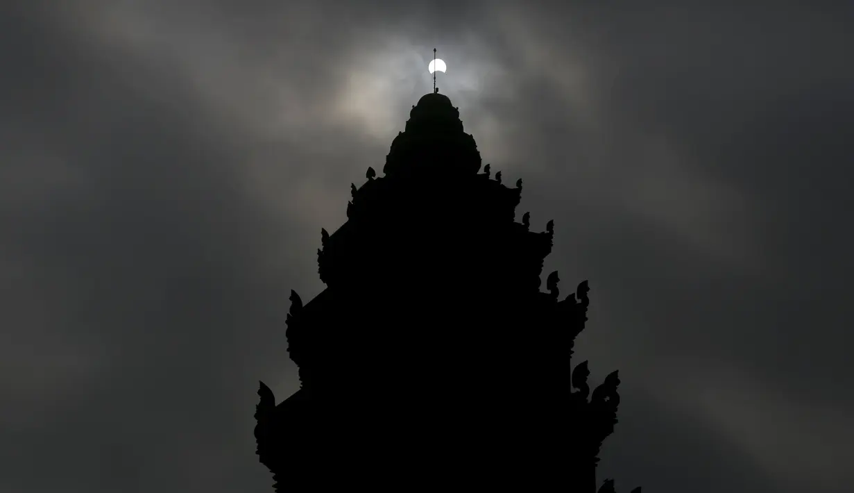 Gerhana matahari parsial terlihat di dekat Monumen Kemerdekaan di Phnom Penh, Kamboja, (9/3/2016). Gerhana matahari total terjadi di sejumlah daerah di Indonesia. (Reuters/ Samrang Pring)