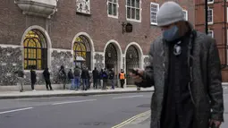 Orang-orang, beberapa memakai masker, mengantre untuk dites, di London, Kamis (16/12/2021). Inggris mencatat 78.610 infeksi baru pada hari Rabu, 16 persen lebih tinggi dari rekor sebelumnya yang ditetapkan pada Januari. (AP Photo/Alberto Pezzali)