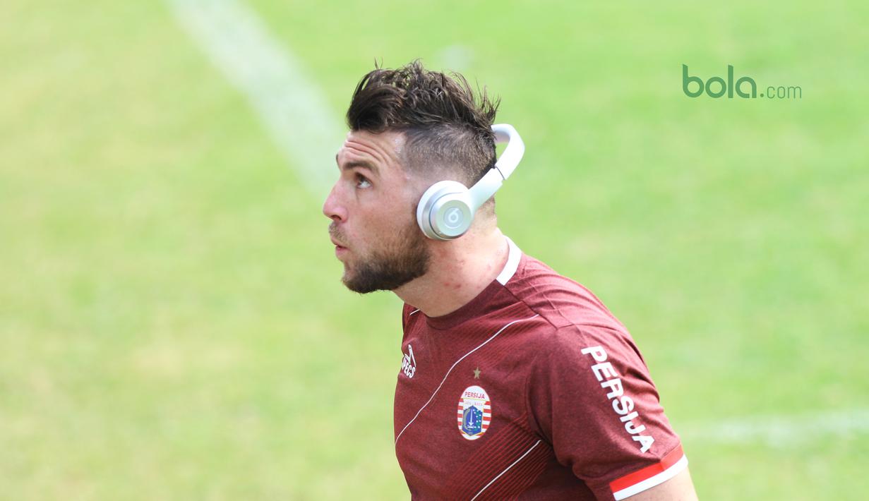 Marko Simic melakukan pemanasan sambil mendengar musik saat latihan jelang melawan Tampines Rovers Piala AFC 2018 di Lapangan ABC, Senayan, Jakarta (27/2/2018). Marko Simic menjadi menjadi salah satu andalan Persija musim 2018. (Bola.com/Nick Hanoatubun)