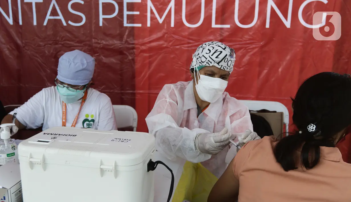 Vaksinator menyuntikkan vaksin Sinovac kepada warga di area TPST Bantargebang, Kota Bekasi, Jumat (29/10/2021). Pihak penyelenggara menyediakan 1000 dosis untuk vaksinasi pertama maupun kedua bagi masyarakat dan komunitas pemulung di sekitar TPST Bantargebang. (Liputan6.com/Helmi Fithriansyah)