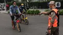 Satpol PP menghentikan pesepeda yang tidak mengenakan masker dengan benar di kawasan Bundaran HI, Jakarta, Minggu (17/1/2021). Pemerintah terus melakukan berbagai upaya guna mencegah penyebaran COVID-19 dan menurunkan angka masyarakat yang terpapar virus corona. (Liputan6.com/Johan Tallo)