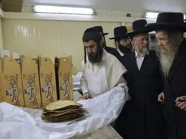 Yahudi Ultra-Ortodoks menyiapkan matzoh spesial di sebuah toko roti di Ashdod, Israel, 11 April 2022. Matzoh adalah roti tradisional tidak beragi yang dibuat untuk Paskah. (AP Photo/Tsafrir Abayov)