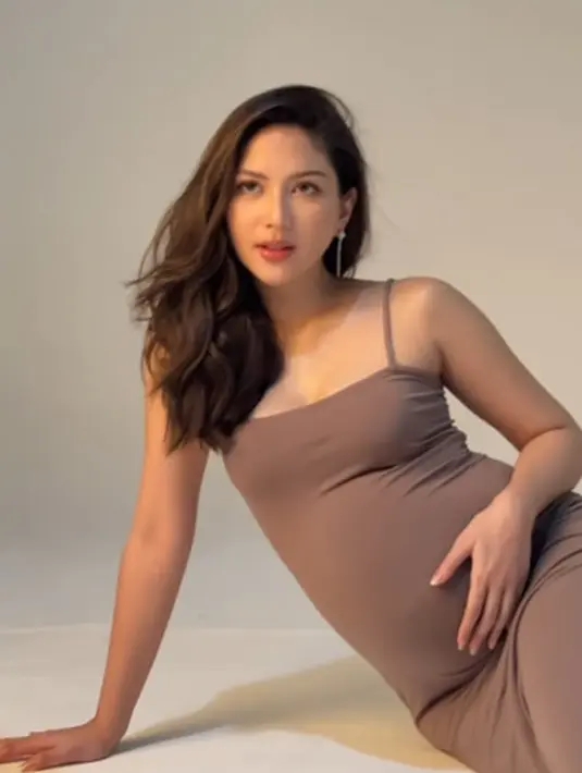 Ia kenakan dress bertali polos berwarna cokelat tua dan makeup flawless glowing [@cherryjks]