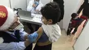 Petugas medis menyuntikkan vaksin covid-19 kepada seorang anak di ibu kota Siprus, Nicosia, Minggu (2/1/2022). Siprus memulai vaksinasi untuk anak-anak berusia antara 5 hingga 11 tahun, di tengah lonjakan tajam kasus virus corona. (Iakovos Hatzistavrou / AFP)