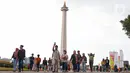 Warga berwisata mengunjungi kawasan wisata Monumen Nasional (Monas) di Gambir, Jakarta Pusat, Jumat (30/6/2023). (Liputan6.com/Angga Yuniar)