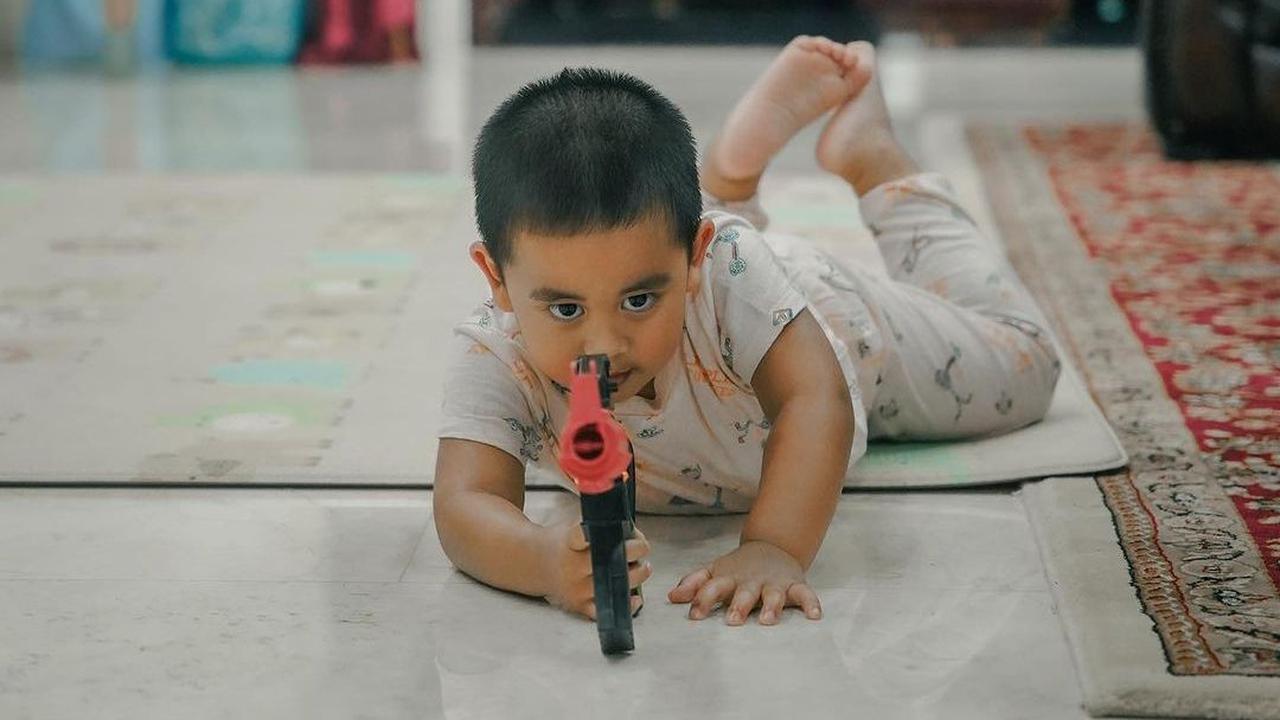 Ia bergaya seolah-olah sedang menembak penjahat.