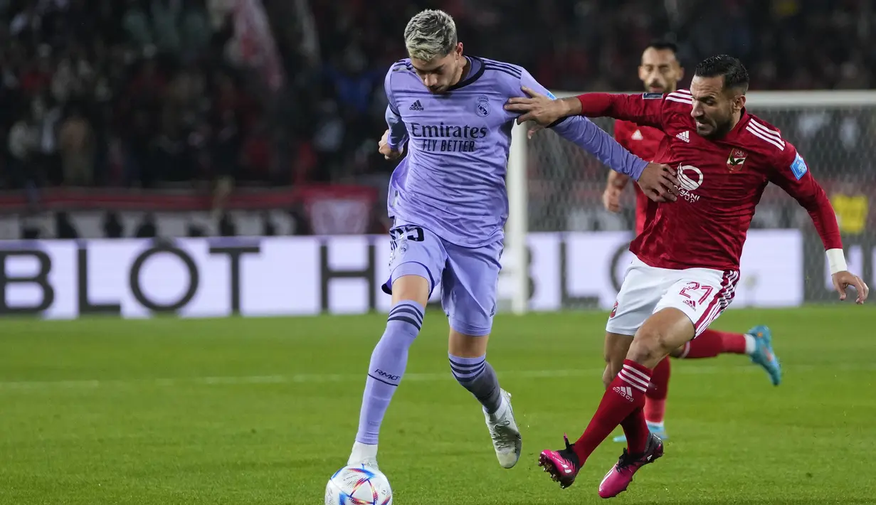 Gelandang Real Madrid Federico Valverde berebut bola dengan bek Al-Ahly Ali Maaloul dalam duel semifinal Piala Dunia Antarklub 2022 di Prince Moulay Abdellah Stadium, Maroko, Kamis (9/2/2023) dini hari WIB. Real Madriddipenuhi pemain bintang yang lebih berpengalaman daripada tim Al Ahly.(AP Photo/Manu Fernandez)