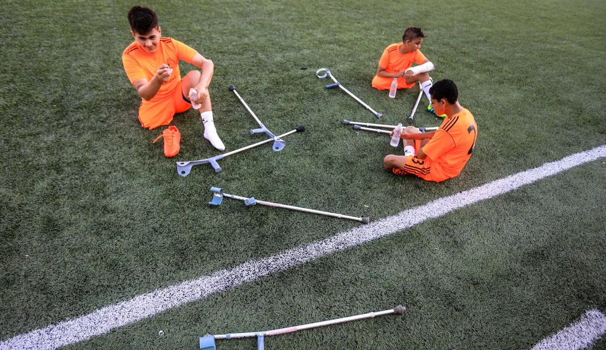 Anak-anak Palestina yang diamputasi bersiap mengikuti sesi pelatihan sepak bola, yang diatur oleh Komite Palang Merah Internasional (ICRC) setelah pembatasan penyakit coronavirus (COVID-19) mereda, di Deir al-Balah di Jalur Gaza tengah (14/7/2020). (AFP/Mahmud Hams)
