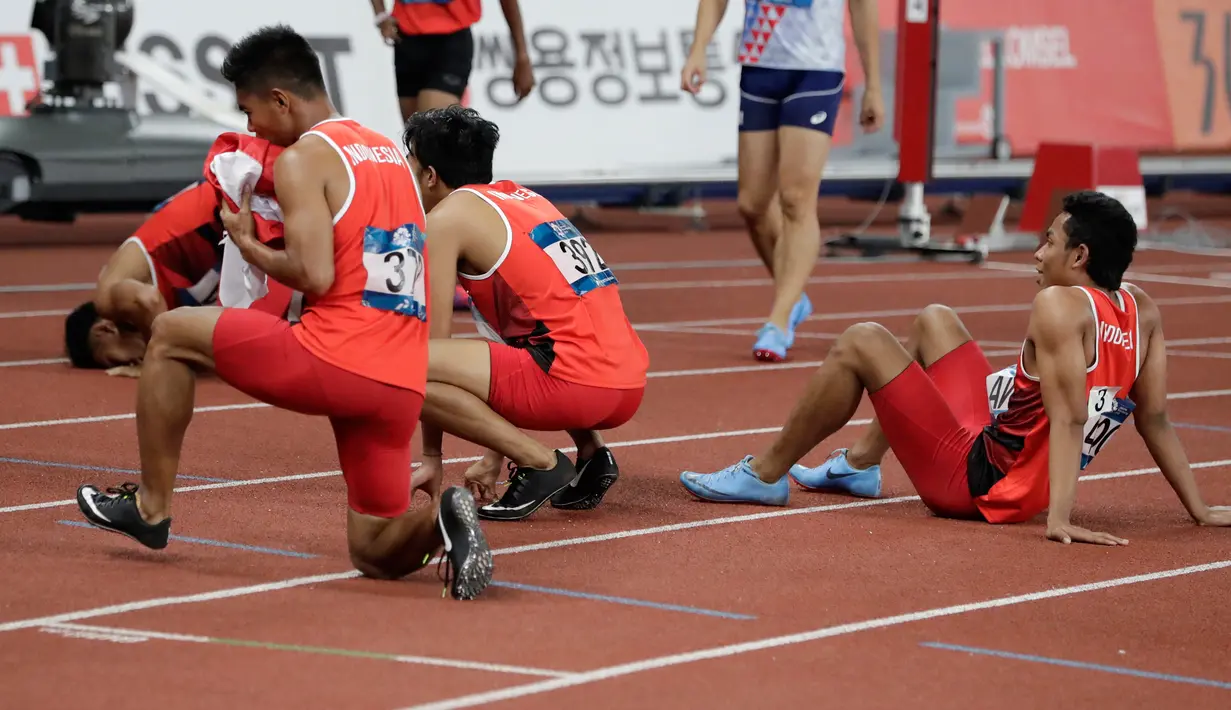 Lalu Muhammad Zohri (kanan) bersama Fadlin, Eko Rimbawan, dan Bayu Kertanegara sujud syukur usai meraih perak dalam final lari 4x100 meter cabang olahraga atletik Asian Games 2018 di Jakarta, Kamis (30/8). (AP Photo/Lee Jin-man)