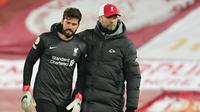 Kiper Liverpool, Alisson Becker (kiri) dihibur manajer tim, Jurgen Klopp usai dikalahkan Burnley 0-1 dalam laga lanjutan Liga Inggris 2020/21 di Anfield Stadium, Kamis (21/1/2021). (AFP/Jon Super/Pool)