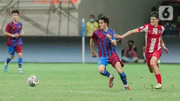 Pemain Barcelona U-18 (tengah) berebut bola dengan pemain Altetico Madrid U-18 pada pertandingan International Youth Championship (IYC) 2021 di Jakarta International Stadium (JIS), Jakarta, Selasa (19/4/2022). Barcelona U-18 menang 1-0. (Liputan6.com/Faizal Fanani)
