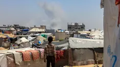 Seorang anak Palestina melihat kepulan asap mengepul dari kejauhan selama pemboman Israel di Rafah, Jalur Gaza Selatan pada 11 Juni 2025. (Foto oleh AFP)