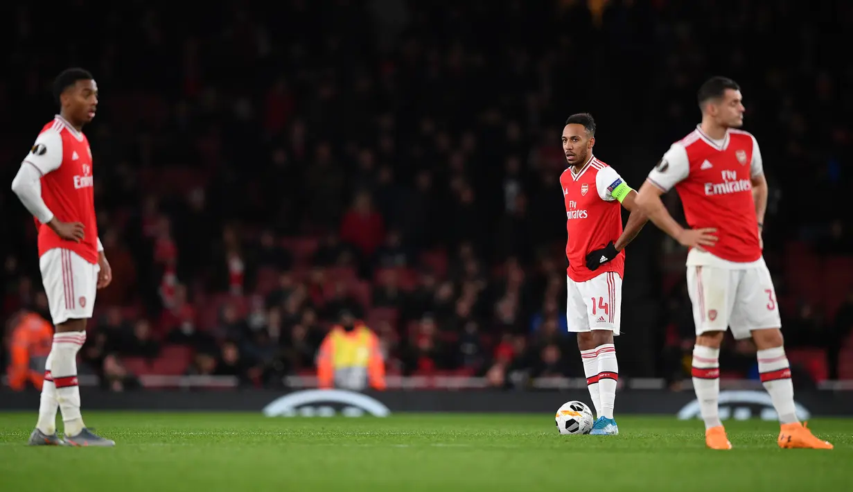Striker Arsenal Pierre-Emerick Aubameyang dan timnya bereaksi setelah gelandang Eintracht Frankfurt, Daichi Kamada mencetak gol pada matchday kelima Grup F Liga Europa di Emirates Stadium, London, Kamis (28/11/2019). Arsenal ditaklukkan Eintracht Frankfurt dengan skor 1-2. (DANIEL LEAL-OLIVAS/AFP)