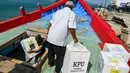 Para pekerja memuat logistik pemilu 2024 ke dalam perahu menuju pulau-pulau terpencil, di Pulo Aceh, Banda Aceh pada 12 Februari 2024. (CHAIDEER MAHYUDDIN/AFP)