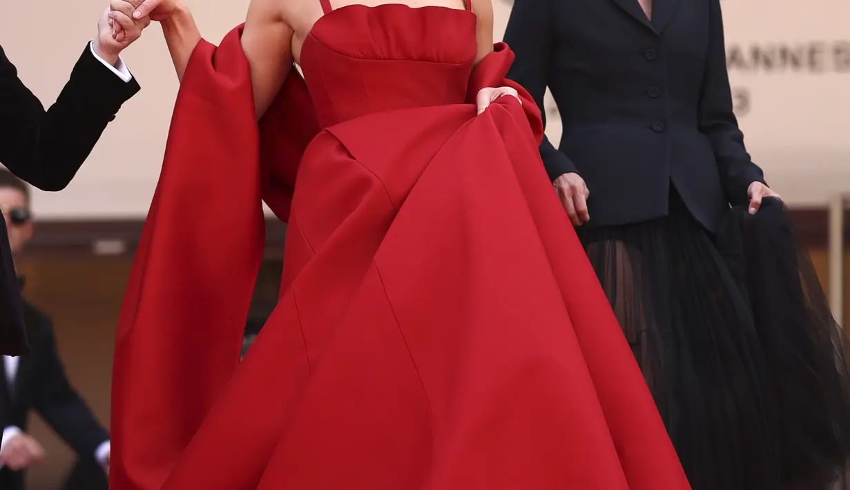 <p>Gaun Jennifer bertali dan tak berlengan, selain dua helai kain yang menutupi lengannya seperti selendang. (Photo by Vianney Le Caer/Invision/AP)</p>