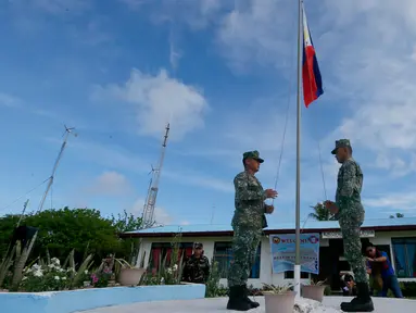  Tentara Filipina menaikan bendera saat mengikuti upacara di Pulau Thitu, Kepulauan Spratly, Laut China Selatan, Jumat (21/4). Pengibaran bendera Filipina yang sebelumnya dibatalkan  Presiden Duterte  akhirnya dilaksanakan. (AP Photo / Bullit Marquez)