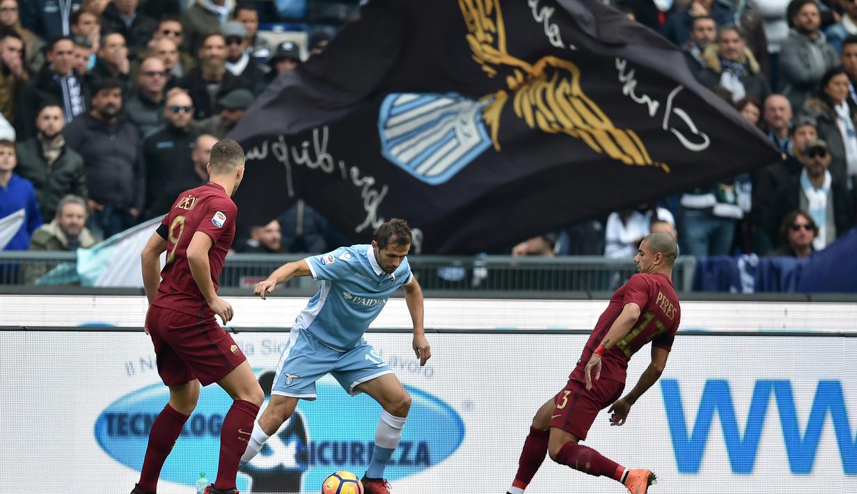 Pemain Lazio, Senad Lulic (tengah) mencoba melewati dua pemain AS Roma  pada laga Derby della Capitale di Olympic Stadium, Roma, Italia, (4/12/2016). AS Roma menang 2-0.  (AFP/Alberto Pizzoli)