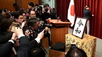 Awak media mengambil gambar plakat nama era baru Kekaisaran Jepang, yakni Reiwa, setelah konferensi pers di kantor perdana menteri, Tokyo, Senin (1/4). Reiwa, menjadi nama era yang baru Jepang mulai 1 Mei 2019 setelah Kaisar Akihito turun takhta pada akhir April mendatang. (Kazuhiro NOGI / AFP)