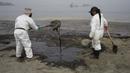 Pekerja mengenakan pakaian pelindung membersihkan Pantai Conchitas yang terkontaminasi tumpahan minyak, di Ancon, Peru, Kamis (20/1/2022). Tumpahan minyak di pantai Peru disebabkan oleh gelombang dari letusan gunung berapi bawah laut di negara Pasifik Selatan Tonga. (AP Photo/Martin Mejia)
