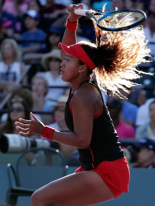 Petenis Jepang, Naomi Osaka mengembalikan bola ke arah mantan petenis nomor satu dunia Serena Williams pada babak pertama Miami Terbuka di Crandon Park, Rabu (21/3). Naomi menaklukan Juara Grand Slam 23 kali itu dengan skor 3-6, 2-6. (AP/Lynne Sladky)