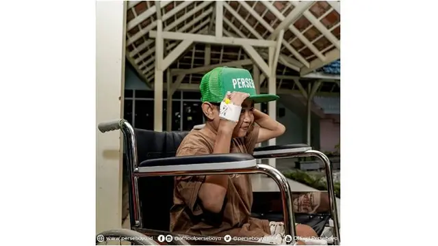 Guruh memakai topi tim sepak bola kebanggaannya