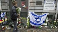Orang-orang meninggalkan bunga di luar Museum Yahudi di Brussel sebagai penghormatan kepada mereka yang terbunuh pada 24 Mei 2014. (AFP)