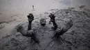 Seorang peserta berendam saat mengikuti Bloco da Lama", pesta mandi lumpur di Paraty, negara bagian Rio de Janeiro, Brasil (2/3). "Bloco da Lama" diketahui sudah ada sejak 1986 lalu. (AFP Photo/Mauro Pimentel)