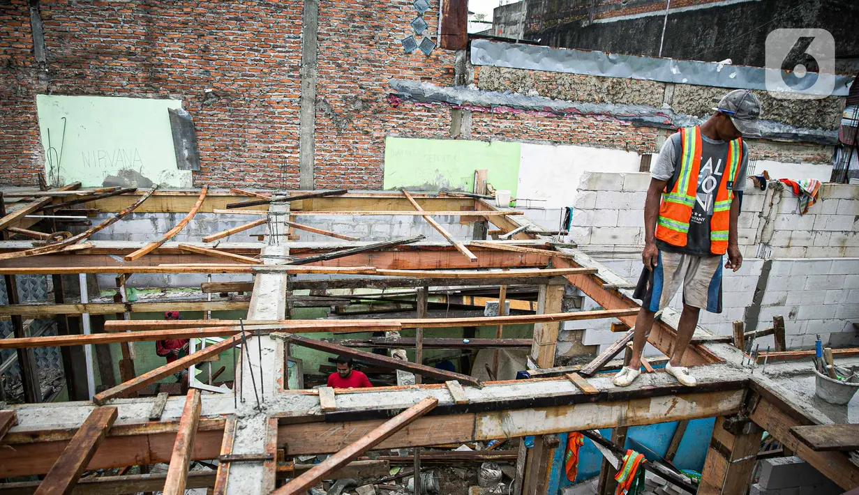 Pekerja saat menyelesaikan pembangunan rumah panggung di dekat bantaran Kali Ciliwung, Kampung Melayu, Jakarta, Rabu (7/4/2021). Pemerintah Provinsi DKI Jakarta melakukan renovasi terhadap 40 hunian warga Kampung Melayu menjadi rumah panggung. (Liputan6.com/Faizal Fanani)