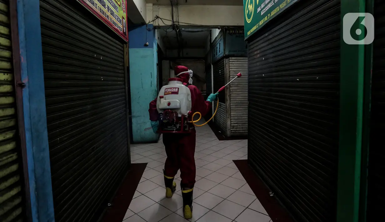 Petugas menyemprotkan Cairan Disinfektan di Pasar Palmerah, Jakarta, Kamis (25/6/2020). Penyemprotan dilakukan guna mencegah dan memutuskan mata rantai penyebaran Covid-19 di Area pasar Palmerah. (Liputan6.com/Johan Tallo)