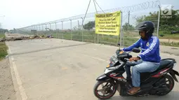 Pengendara sepeda motor berputar arah saat Jalan Perimeter Utara diblokir warga, Rawa Rengas, Kosambi, Tangerang, Banten, Selasa (2/7/2019). Proses hukum akses menuju Bandara Soekarno-Hatta (Soetta) tersebut masih berlangsung di Pengadilan Negeri Tangerang. (merdeka.com/Arie Basuki)