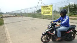 Pengendara sepeda motor berputar arah saat Jalan Perimeter Utara diblokir warga, Rawa Rengas, Kosambi, Tangerang, Banten, Selasa (2/7/2019). Proses hukum akses menuju Bandara Soekarno-Hatta (Soetta) tersebut masih berlangsung di Pengadilan Negeri Tangerang. (merdeka.com/Arie Basuki)