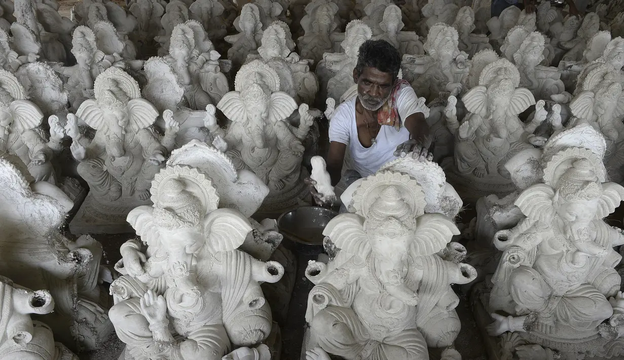 Perajin menyelesaikan pembuatan patung Dewa Ganesha di sebuah bengkel di pinggiran Hyderabad, India, Senin (29/6/2020). Patung Dewa Ganesha banyak ditemukan di berbagai penjuru India termasuk Nepal, Tibet, dan Asia Tenggara. (NOAH SEELAM/AFP)