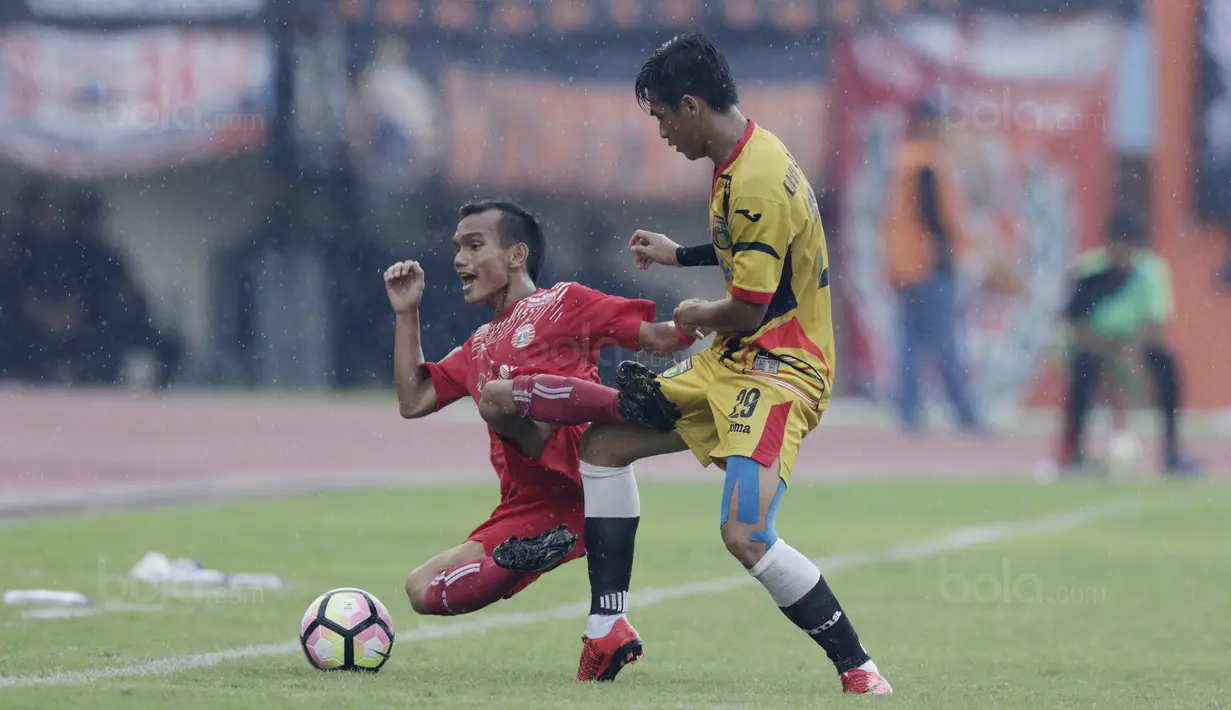 Gelandang Persija, Riko Simanjuntak, terjatuh saat berebut bola dengan Gelandang Mitra Kukar, Septian David Maulana, pada laga Piala Presiden di Stadion Manahan, Solo, Minggu, (4/2/2018). Persija menang 3-1 atas Mitra Kukar. (Bola.com/M Iqbal Ichsan)
