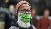 Seorang pria tua mengenakan masker di bawah hidungnya dan berjalan di area pasar di Jammu, India, Sabtu, 15 Januari 2022. Beberapa pemerintah daerah, seperti yang ada di ibu kota New Delhi, telah merekrut staf baru untuk memastikan aturan wajib masker dipatuhi. (AP Photo/Channi Anand)