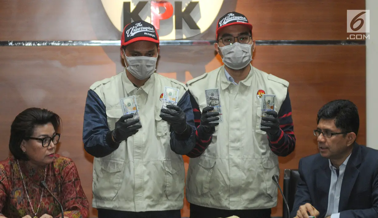 Petugas disaksikan Wakil Ketua KPK Basaria Panjaitan dan Laode M Syarif menunjukkan barang bukti hasil OTT Bupati Muara Enim uang 350.000 dollar AS di Gedung KPK, Jakarta, Selasa (3/9/2019). Uang tersebut terkait suap 16 proyek peningkatan pembangunan jalan di Muara Enim. (merdeka.com/Dwi Narwoko)