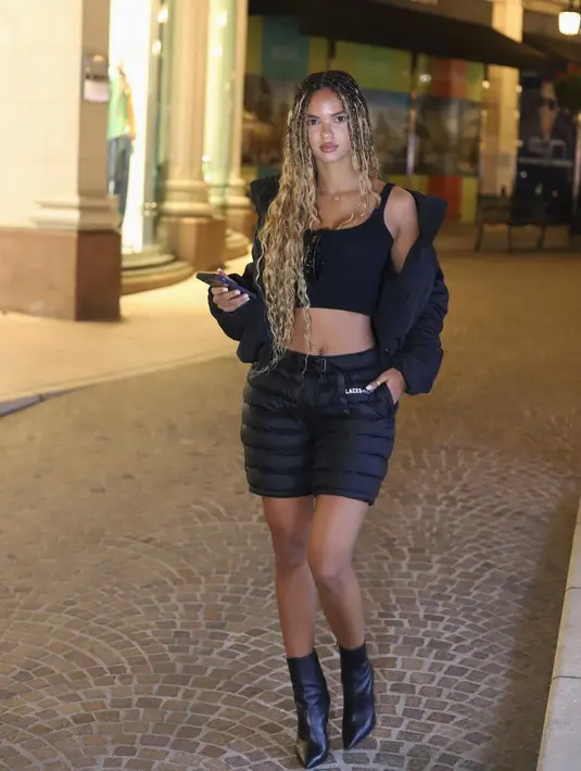 Pose Juliana Nalu dalam outfit serba-hitam lewat set rok mini dan jaket puffer yang funky. (IG @juliananalu)