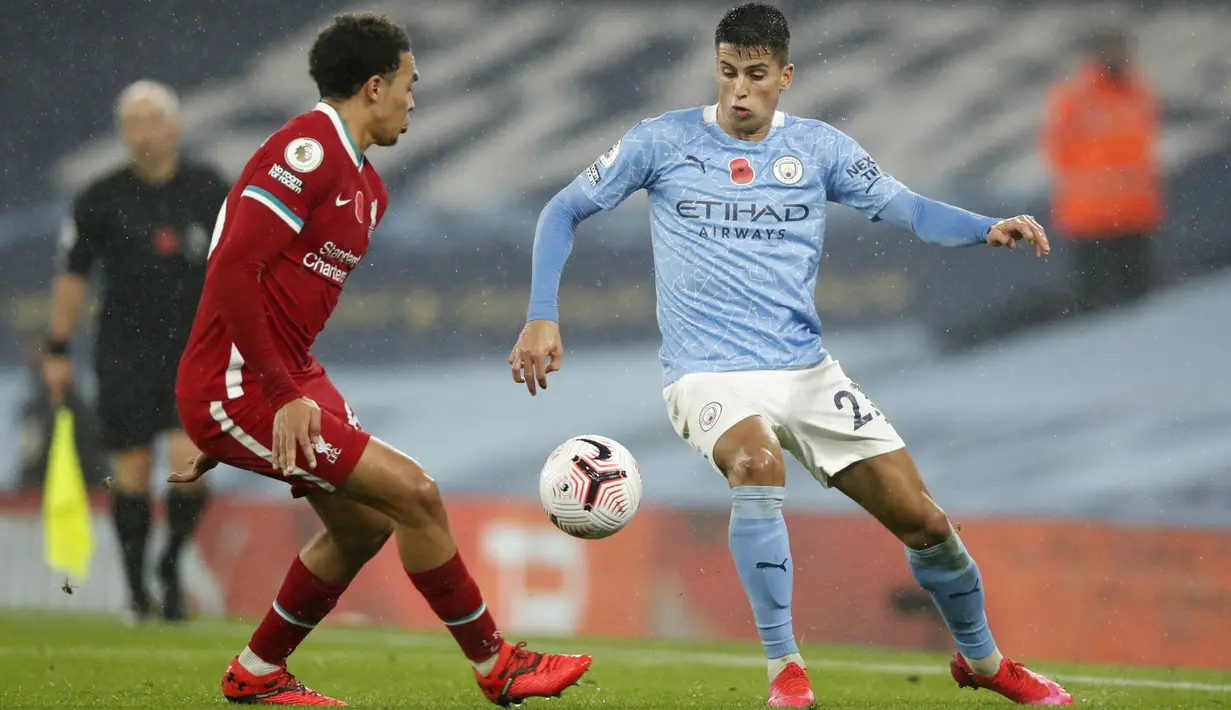 Bek Manchester City Joao Cancelo dan Trent Alexander-Arnold dari Liverpool berebut bola pada pertandingan Liga Inggris pekan ke-8 di Etihad Stadium, Minggu (8/11/2020). City gagal mengalahkan Liverpool dan harus puas berbagi angka setelah bermain imbang 1-1. (Clive Brunskill/Pool via AP)