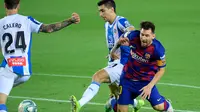 Mega bintang Barcelona, Lionel Messi, berebut bola dengan gelandang Espanyol, Marc Roca pada lanjutan pertandingan La Liga Spanyol di Camp Nou, Kamis (9/7/2020) dini hari WIB.  Barcelona menang tipis 1-0 atas Espanyol lewat gol yang dicetak Luis Suarez. (LLUIS GENE / AFP)