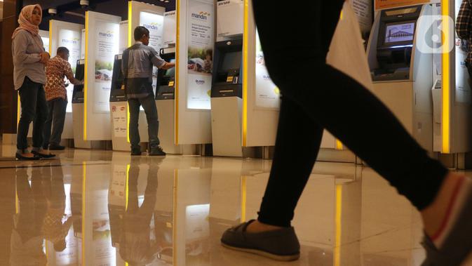 Nasabah melakukan transaksi elektronik perbankan melalui ATM di Jakarta, Selasa (4/2/2020). Transaksi kanal elektronik Bank Mandiri sepanjang 2019 juga terdongkrak naik empat persen secara yoy menjadi  Rp 2,1 miliar transaksi dengan nilai finansial sebesar Rp 3,1 triliun. (Liputan6.com/Angga Yuniar)