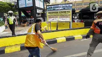 Warga pelanggar Pembatasan Sosial Berskala Besar (PSBB) dihukum menyapu jalanan saat terjaring razia masker di wilayah Tanah Abang, Jakarta, Senin (14/9/2020). Razia tersebut guna menekan kasus penyebaran COVID-19 di Jakarta pada masa PSBB. (Liputan6.com/Johan Tallo)