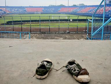 Sepasang sepatu terlihat di tribun Stadion Kanjuruhan setelah tragedi kerusuhan pada pertandingan sepak bola antara Arema Vs Persebaya di Malang, Jawa Timur, Minggu (2/10/2022). Dunia sepak bola Indonesia kembali berduka menyusul terjadinya kerusuhan pascapertandingan Arema vs Persebaya. (AP Photo/Hendra Permana)