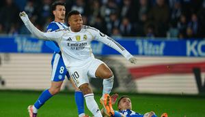 Pemain Real Madrid, Kylian Mbappe, mencoba lepas dari penjagaan bek Deportivo Alaves saat kedua tim bertarung dalam lanjutan Liga Spanyol 2025/2025, Senin (15/12/2025) dini hari WIB. (AP Photo/Miguel Oses)