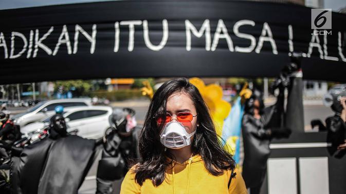 Massa aksi yang tergabung dalam gerakan masyarakat non partisan #BersihkanIndonesia menggenakan masker saat aksi teatrikal di lintasan penyeberangan orang atau Pelican crossing di Jakarta, Kamis (20/12). (Liputan6.com/Faizal Fanani)